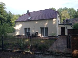 a white house with a fence in front of it at Haus Waldidyll in Lauta