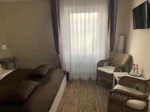 a bedroom with a bed and a chair and a window at Hotel Admiral Scheer in Laboe