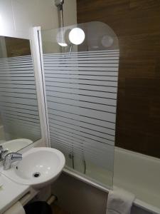 un bagno con lavandino, specchio e finestra di Euro Hôtel Airport Orly Rungis a Fresnes