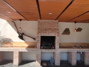 Cadalso de los VidriosにあるCasa Rural Mirando a Gredosの天井のリビングルームにレンガ造りの暖炉