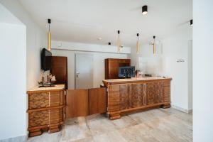 eine Küche mit Holzschränken und einem Fernseher in einem Zimmer in der Unterkunft Horeka Hotel & SPA in Lyck