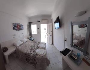 a bedroom with a bed and a television in it at Rooms to let Rena in Monolithos