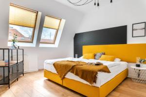 sypialnia z dużym łóżkiem z żółtym zagłówkiem w obiekcie LeoApart we Wrocławiu