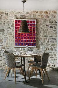 a dining room with a table with chairs and a painting at The View - Gite Mont Dore in Montpeyroux +3 photos