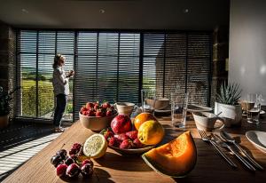 una persona tomando una foto de una mesa con fruta en ella en The View - Gite Mont Dore, en Montpeyroux