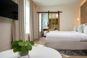 a hotel room with two beds and a television at Hôtel des Champs-Elysées in Paris