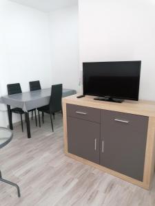 uma televisão numa bancada com uma mesa e cadeiras em Apartamento el Castellar em Puerto de Mazarrón