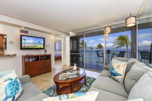 a living room with a couch and a tv at Royal Kahana 409 in Lahaina
