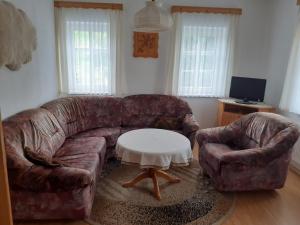 a living room with a leather couch and a coffee table at Ferienhaus Grabs in Lichtenhain