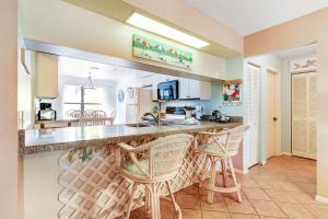 cocina con 2 taburetes y encimera en Beach View 5, en Holmes Beach