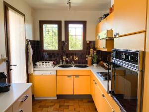 a kitchen with orange cabinets and a sink at 4AMB2 Villa de caractère avec piscine collective in Collioure