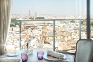 a table with a glass of wine on top of it at Hotel Sevilla Center in Seville