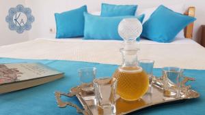 - un plateau avec une bouteille de jus d'orange et des verres sur un lit dans l'établissement Katerina Rodon Apartments, à Nea Roda