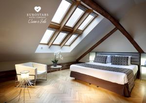 
a bedroom with a large bed and a large window at Eurostars Thalia in Prague
