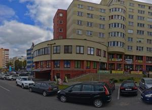 um grande edifício com carros estacionados num parque de estacionamento em EXCLUSIVE EuApartments em Hrodna