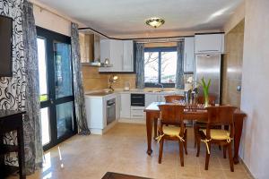 uma cozinha com uma mesa e cadeiras e um frigorífico em Finca el Vinche em Guía de Isora