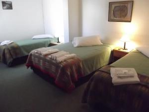 Habitación de hotel con 2 camas y toallas. en Hosteria Las Amapolas en San Carlos de Bariloche