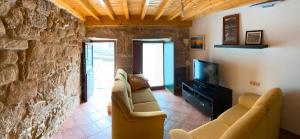 - un salon avec deux canapés et une télévision dans l'établissement A Casa de Feli, à Muros