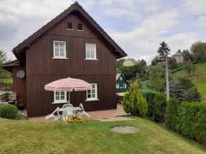a house with a table and an umbrella at Ferienhaus Grabs in Lichtenhain