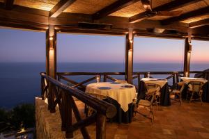 a restaurant with tables and chairs on a balcony at Monastero Santa Rosa Hotel & Spa in Conca dei Marini