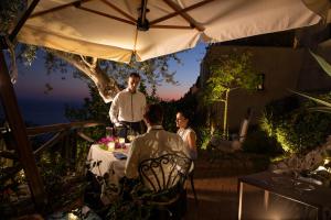 a woman standing next to a man at a table at Monastero Santa Rosa Hotel & Spa in Conca dei Marini