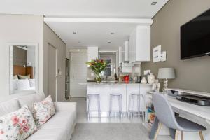 a living room with a couch and a kitchen at Lux Andringa Walk Apartments in Stellenbosch