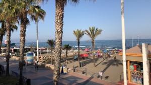 plaża z palmami i ludźmi i oceanem w obiekcie Nice studio with pool and internet fiber w mieście Torremolinos