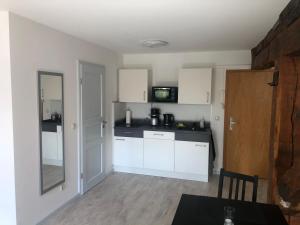 Una cocina con gabinetes blancos y una encimera negra. en Atelier Altstadt Stralsund, en Stralsund 5 fotos más