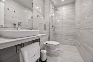 a white bathroom with a sink and a toilet at Connect Living Apartments Free Parking in Sofia +52 photos