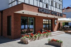 a building with a bunch of flowers in front of it at Hotel Horeka in Ełk
