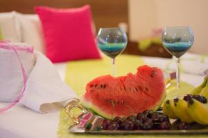 two glasses of wine and a plate of watermelon and grapes at Bellisimo studios in Zakynthos