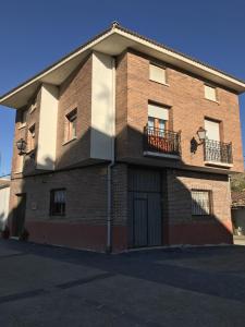 un gran edificio de ladrillo con 2 balcones. en La Cabañita de Leiva, en Leiva