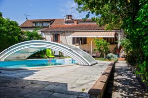a bridge over a swimming pool in front of a house at La petite Pierrette in Saint-Benoît-de-Carmaux