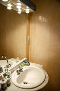 a bathroom with a white sink and a mirror at La petite Pierrette in Saint-Benoît-de-Carmaux