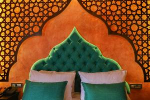 a bed with a green headboard and two pillows at DECAN Concept Boutique Estate in Rhodes Town