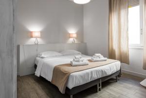 - une chambre avec un grand lit et des serviettes dans l'établissement Flats4Rent La dimora d'Orlando, à Vérone