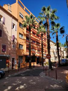 a street with palm trees in front of a building at Le Richelieu in Le Boulou +31 photos