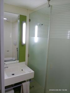 a bathroom with a shower and a sink and a mirror at Hotel Caspia Pro Greater Noida in Greater Noida