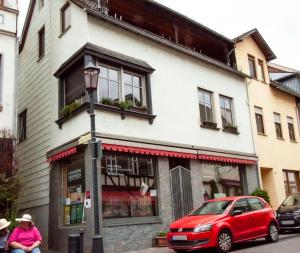 a red car parked in front of a building at Ferienwohnung Marion in Oberwesel