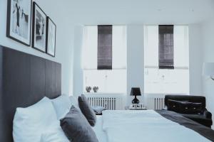 a bedroom with a white bed and a black chair at Boutique Hotel Classico Bremen in Bremen