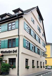 un bâtiment blanc avec des fenêtres et des plantes. dans l'établissement Hotel Eberbacher Hof, à Biberach an der Riß