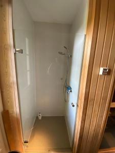 Un baño con ducha con puerta de cristal. en Luxe tuinhuis nabij Amsterdam, en Oostzaan