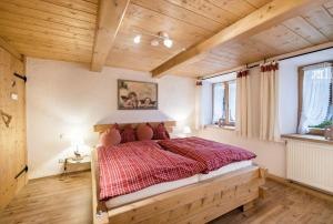 een slaapkamer met een groot bed in een kamer met houten plafonds bij Ferienwohnung Zugspitze in Grainau