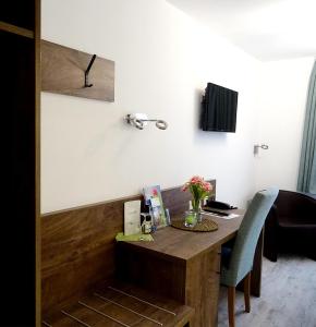 a desk with a vase of flowers on it at Hotel Eberbacher Hof in Biberach an der Riß