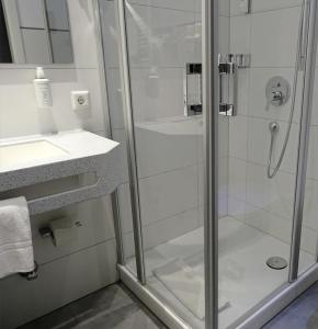 a bathroom with a shower with a glass door at Hotel Eberbacher Hof in Biberach an der Riß