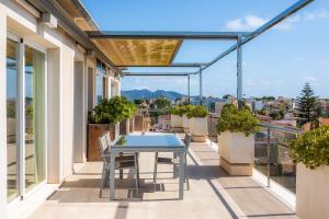 een patio met een tafel en stoelen op een balkon bij Ático Las Palmeras in Cala Millor