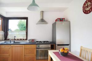 a kitchen with a refrigerator and a table with a bowl of fruit at Sosnowy Domek Krasnobród in Krasnobród