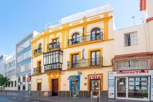 een geel gebouw aan de straatkant bij Genteel Home Amor de Dios in Sevilla