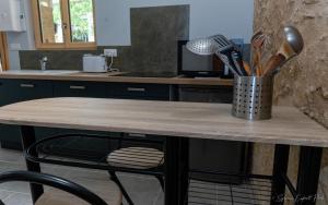 a kitchen counter with a table with utensils on it at I love Bergerac in Bergerac