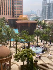 Times Square Kuala Lumpur JN في كوالالمبور: بركة سباحة كبيرة مع أشجار النخيل والناس في المدينة